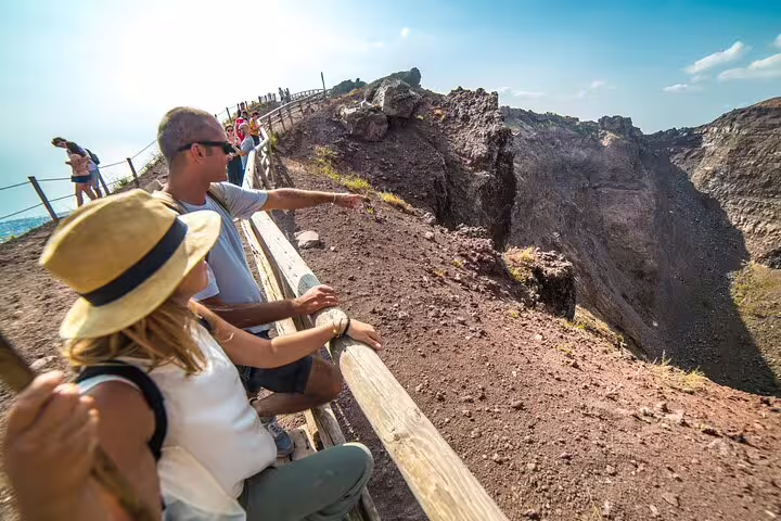 Visitors explore the rugged volcanic landscape of Mt. Vesuvius, enjoying panoramic views on a guided tour from Sorrento.