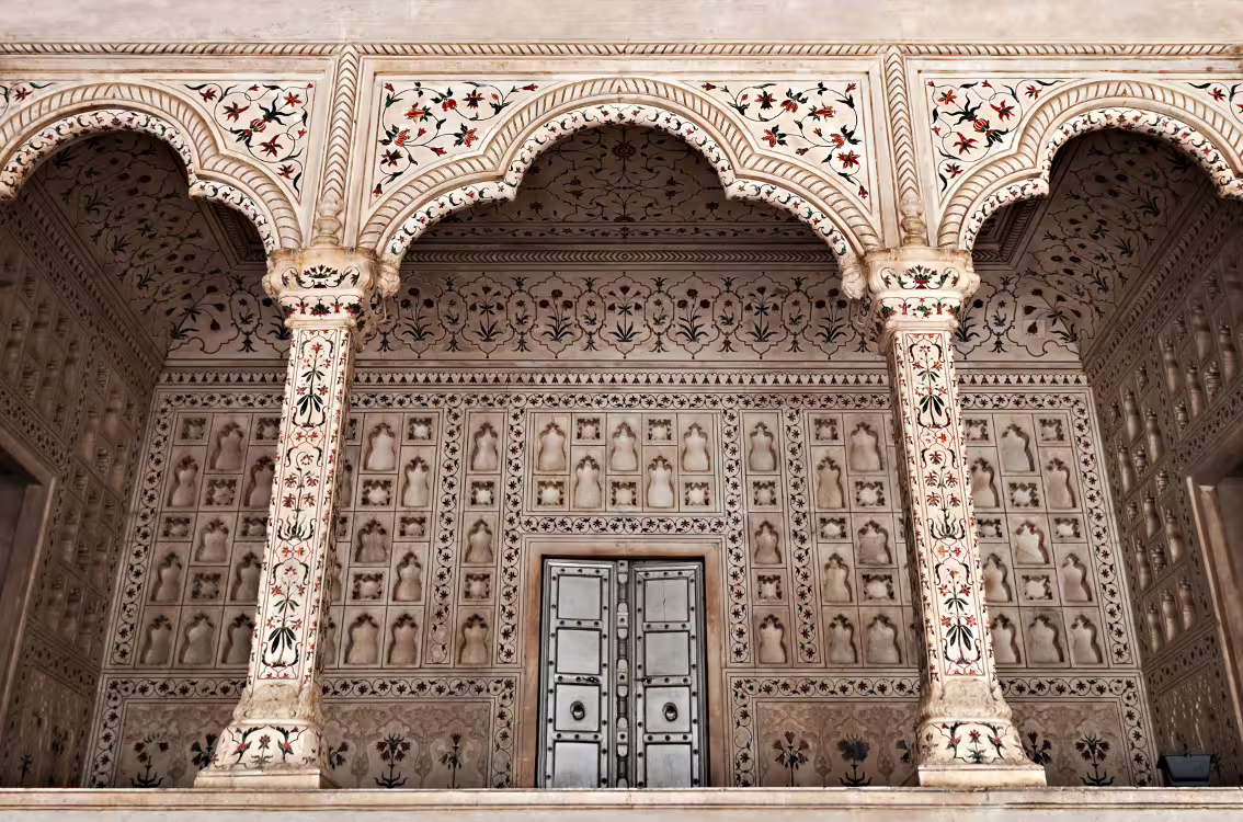 Intricate Mughal architecture with floral inlay designs at Agra Fort, showcasing classical North Indian craftsmanship.