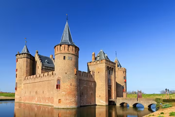 Muiderslot Castle reflected in the moat, stop on a private tour from Amsterdam to Kinderdijk and Gouda