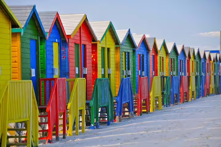 Vibrant, colorful beach huts at Muizenberg Beach, a highlight on the Half Day Penguins and Cape of Good Hope Tour.