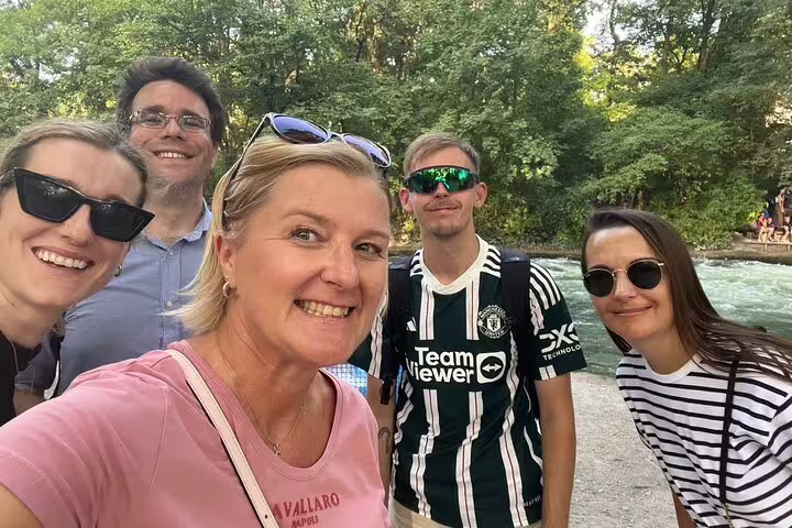 Smiling group at Munich Eisbach stream in the English Garden on a self-guided scavenger hunt tour