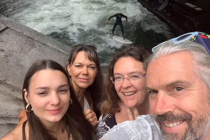 Group selfie by Eisbachwelle river surfer, fun stop on Munich scavenger hunt and sights self-guided tour