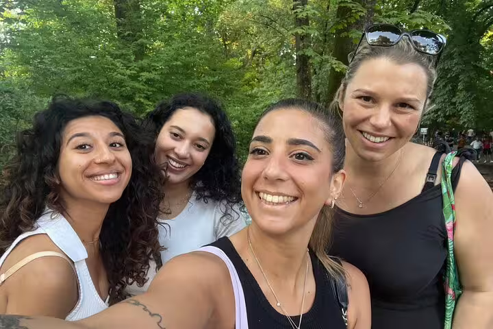 Group selfie in a leafy Munich park while exploring city sights on a self-guided scavenger hunt tour