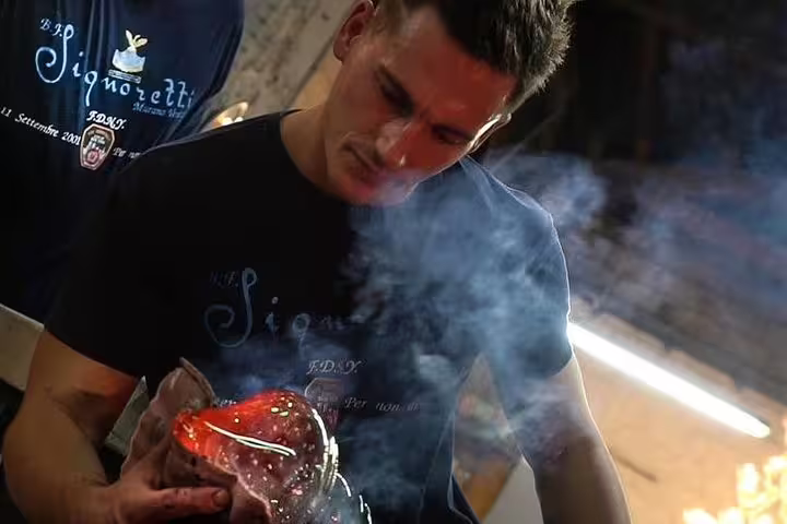 Murano glass artisan shaping hot glass with tools, an authentic stop on a private boat tour Murano & Burano