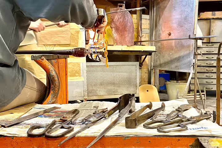 Glass artisan crafting intricate designs at a Murano workshop on the Grand Canal tour from San Marco Square.