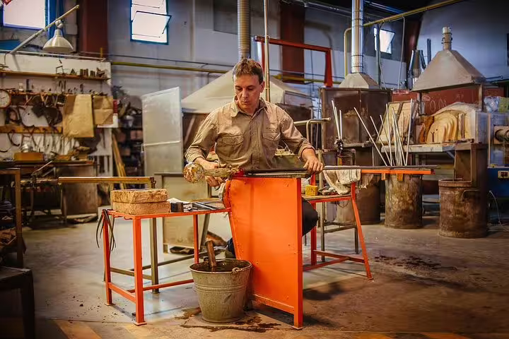 Skilled artisan crafting Murano glass in a traditional workshop during a private Grand Canal boat tour.