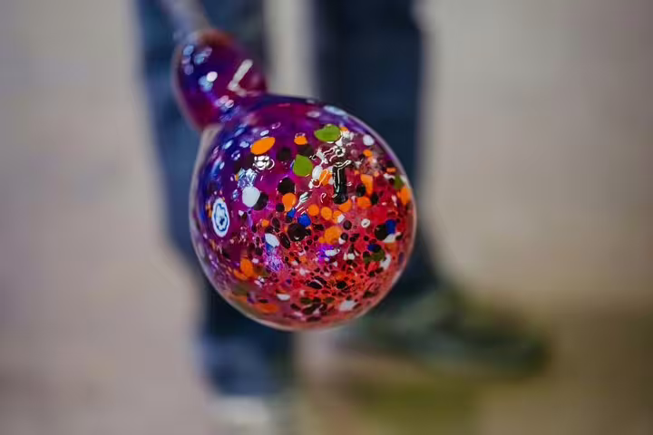 Close-up of vibrant, multicolored glass artwork being crafted in Murano during a shared tour experience.