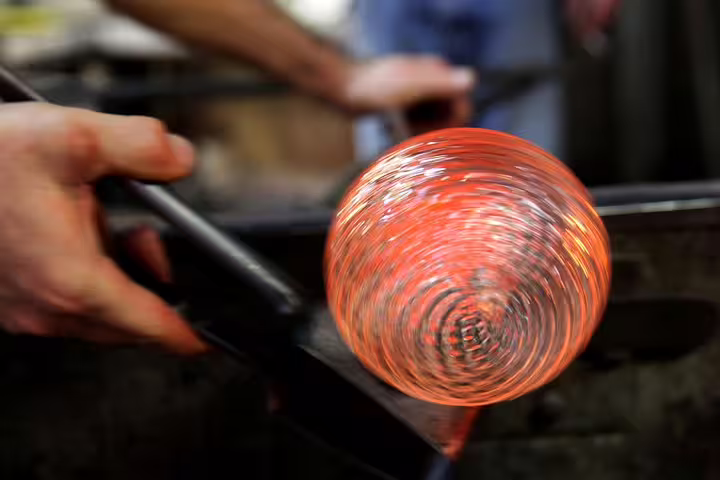 Close-up of a glowing glasswork in progress at a Murano glass factory, part of the Private LimoBoat Tour experience.