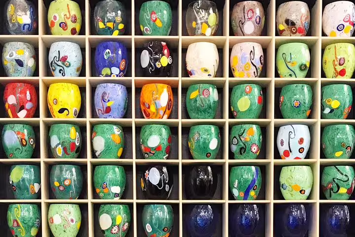 Colorful Murano glass pieces displayed in a grid, showcasing unique designs on the shared tour.