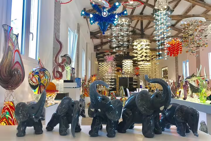 Exquisite glass elephant sculptures in a Murano showroom, representing the unique artistry on a Grand Canal tour.