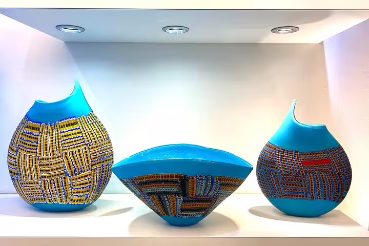Elegant blue and patterned Murano glass vases displayed, highlighting Italian artistry on a Murano boat tour.