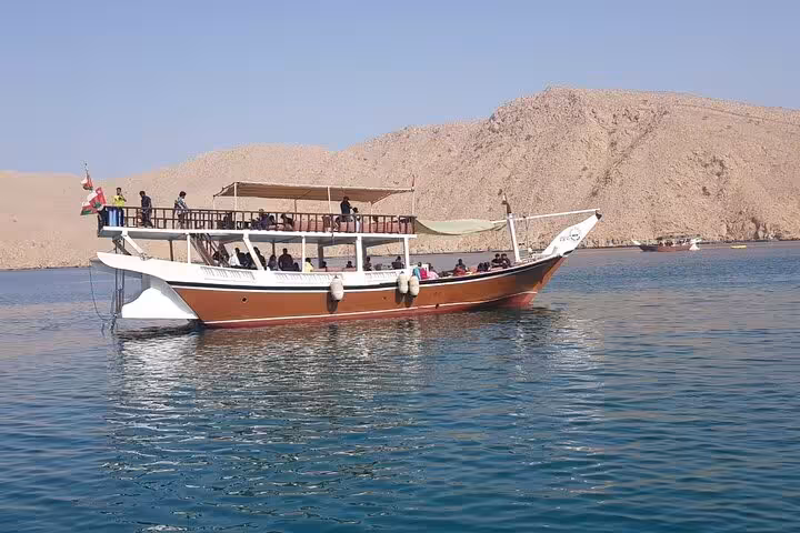 Traditional Musandam dhow boat cruising calm fjords, scenic day trip with fishing, snorkeling and lunch onboard