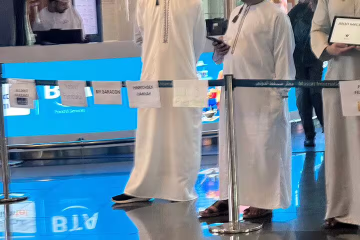 Traditional Omani greeters at Muscat Airport, ready to assist with taxi transfers and hotel accommodations for arrivals.