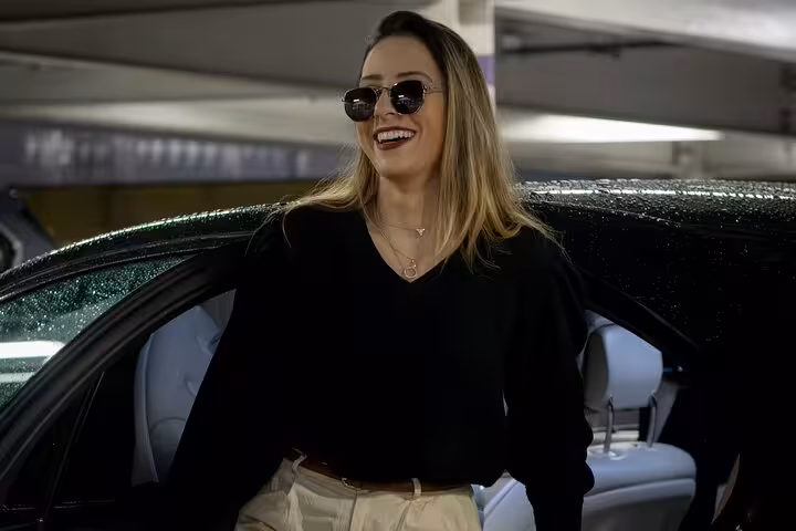 Smiling traveler steps out of a premium car at Muscat Airport, enjoying a private, stress-free arrival transfer service