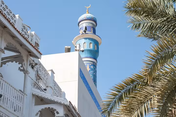 Close-up of ornate blue minaret and traditional architecture in Mutrah captured on the Premier Classic Muscat cab tour