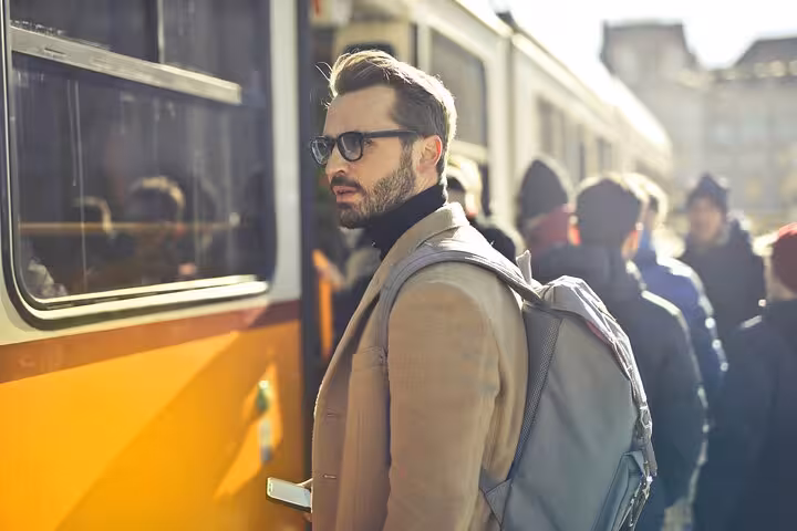 Business traveler with backpack boarding transport, ideal for Muscat to Dubai private transfer and city connection