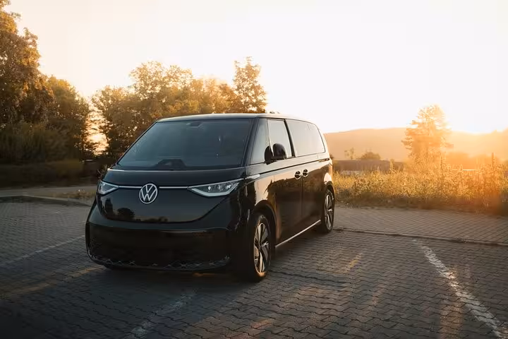 Sleek black minivan at sunrise ready for Muscat to Dubai private transfer, offering spacious, premium door-to-door service