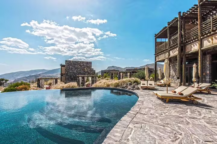 Luxurious mountain resort with infinity pool overlooking Jabal Al Akhdar, showcasing a premium private transfer destination from Muscat.