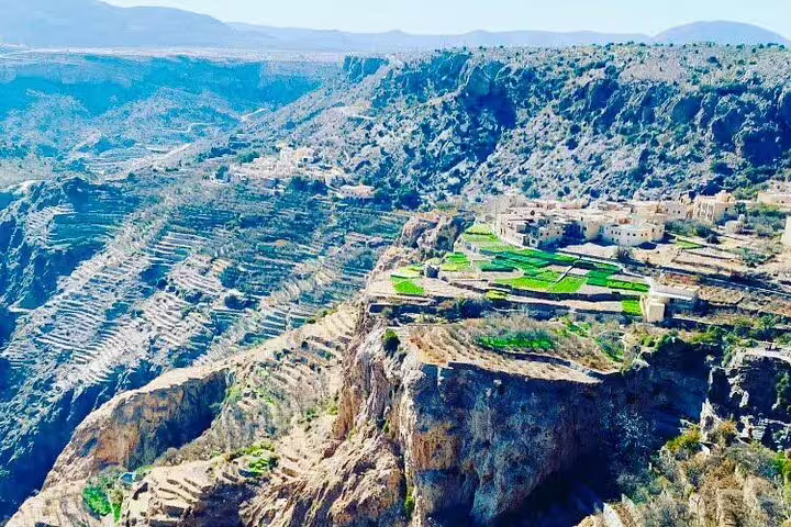 Scenic view of Jebel Akhdar's terraced farms and rugged cliffs, an ideal stop on a private transfer from Muscat.