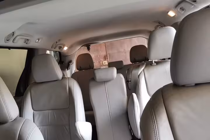 Spacious air-conditioned minivan interior with comfortable leather seats for private transfer from Muscat to Nizwa