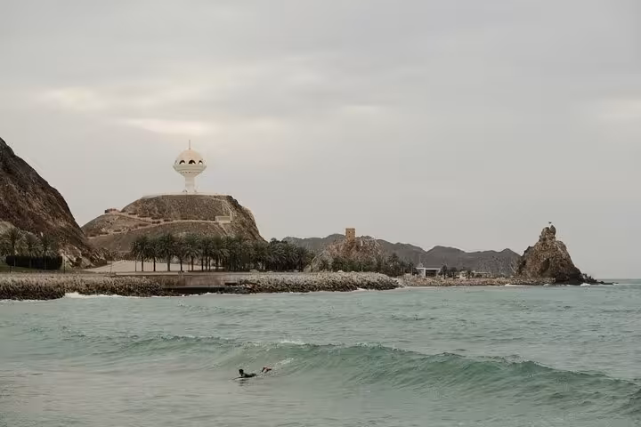 Coastal view of Muscat’s iconic Riyam incense burner, rocky hills and turquoise sea on a private classic city sightseeing tour