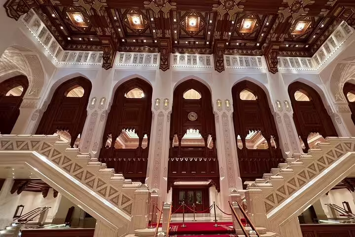 Grand interior view of Oman's Royal Opera House with ornate arches and a luxurious staircase, perfect for a Muscat city tour.