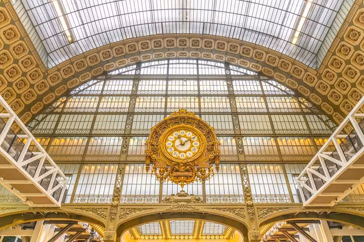 Ornate golden clock inside Musée d’Orsay, a top museum included with the Full Day Paris City Pass
