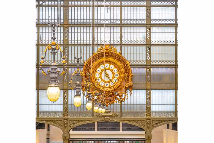 Ornate golden clock inside Musée d'Orsay, included with Paris private Seine walk and skip-the-line museum tickets