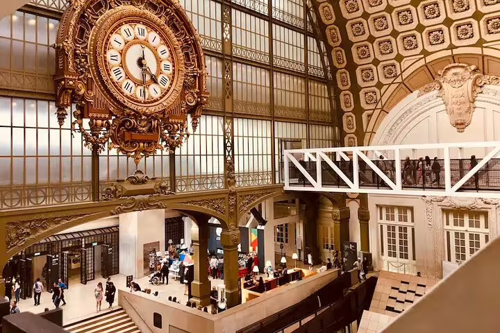 Interior of Musée d’Orsay with grand Beaux-Arts clock and visitors exploring the former railway station on a private guided tour