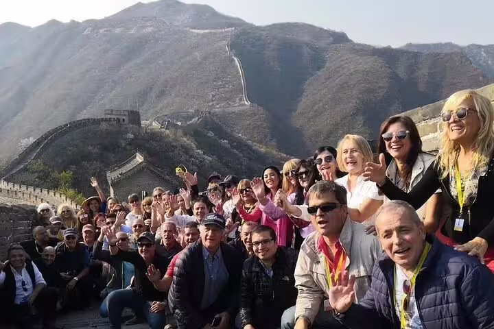 Happy group of tourists on the Mutianyu Great Wall, enjoying a private day trip with an English-speaking driver.