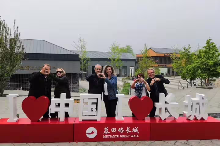 Tourists pose with 'I Love China' sign at Mutianyu Great Wall, perfect for a memorable private day tour.