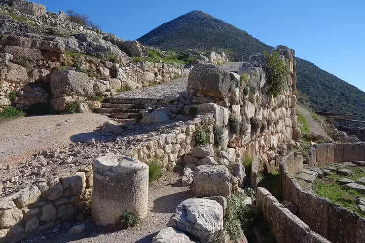 Ancient stone pathway and ruins at Mycenae, a highlight of the 2-day Peloponnese tour from Athens