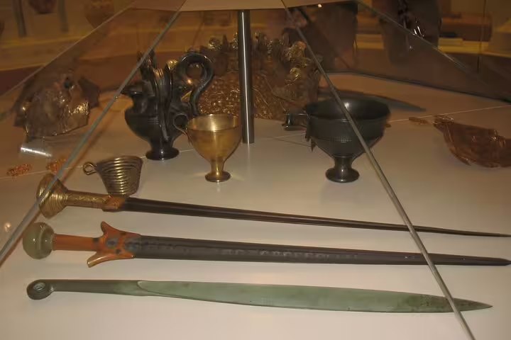 Mycenaean bronze swords and gold cups in museum display, included on Mycenae and Nafplio private tour