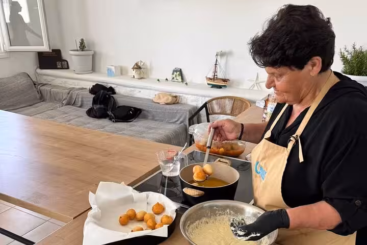 Local chef fries traditional Greek croquettes in Mykonos cooking class, hands-on culinary experience for cruise ship guests