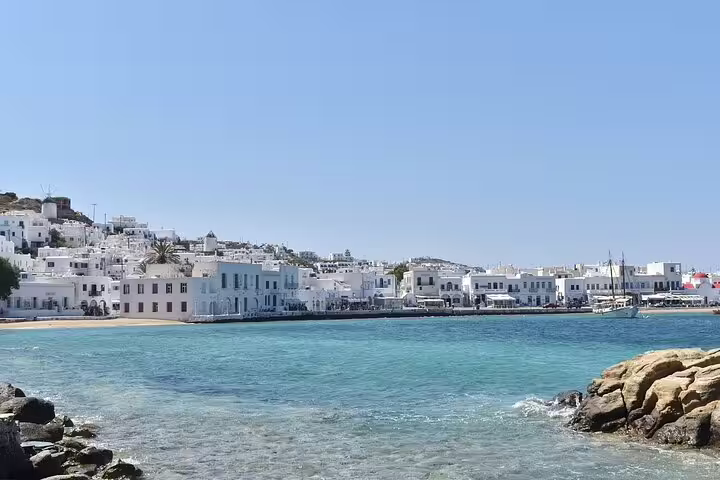 Scenic view of Mykonos coastline with traditional white buildings, clear blue sea, perfect for a countryside and tasting experience ride.