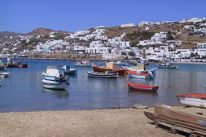Mykonos harbor with colorful fishing boats and whitewashed hillside houses on a 2-day tour from Athens