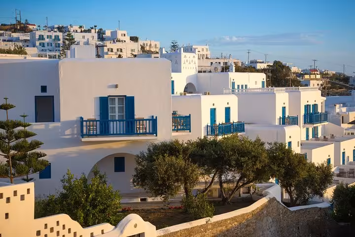 Whitewashed Mykonos town houses with blue balconies, a highlight on a day tour from Athens to Mykonos