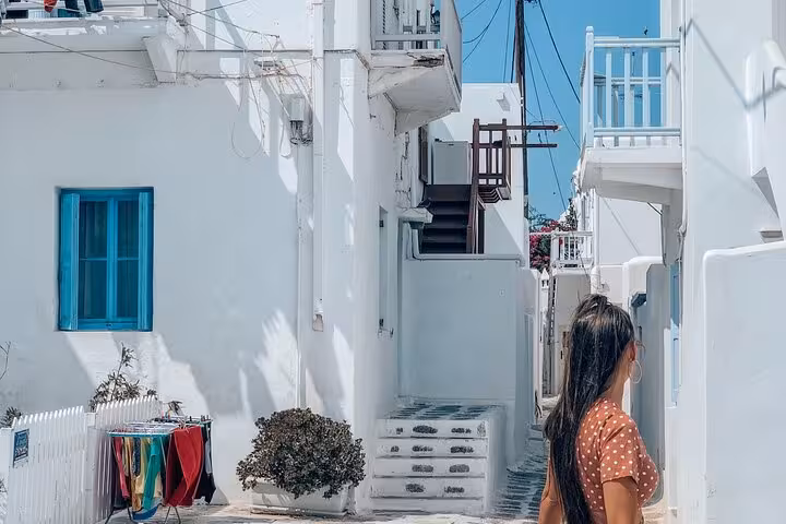 Traveler exploring a whitewashed lane in Mykonos Chora on a small group walking tour in Greece