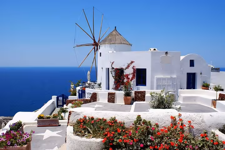 Mykonos windmill and whitewashed Cycladic houses by the Aegean Sea, featured on 2-day Athens island tour