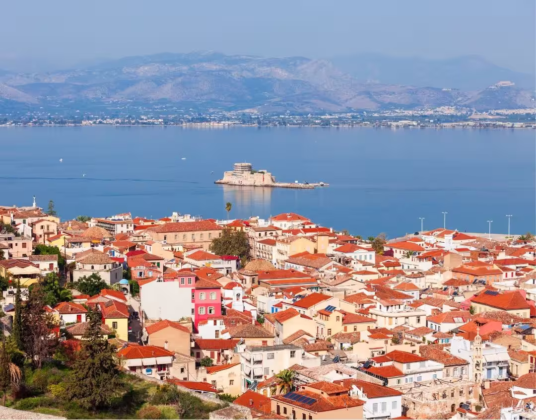 Scenic view of Nafplio's colorful rooftops and Bourtzi Castle in the Peloponnese, ideal for a cultural day trip with lunch.