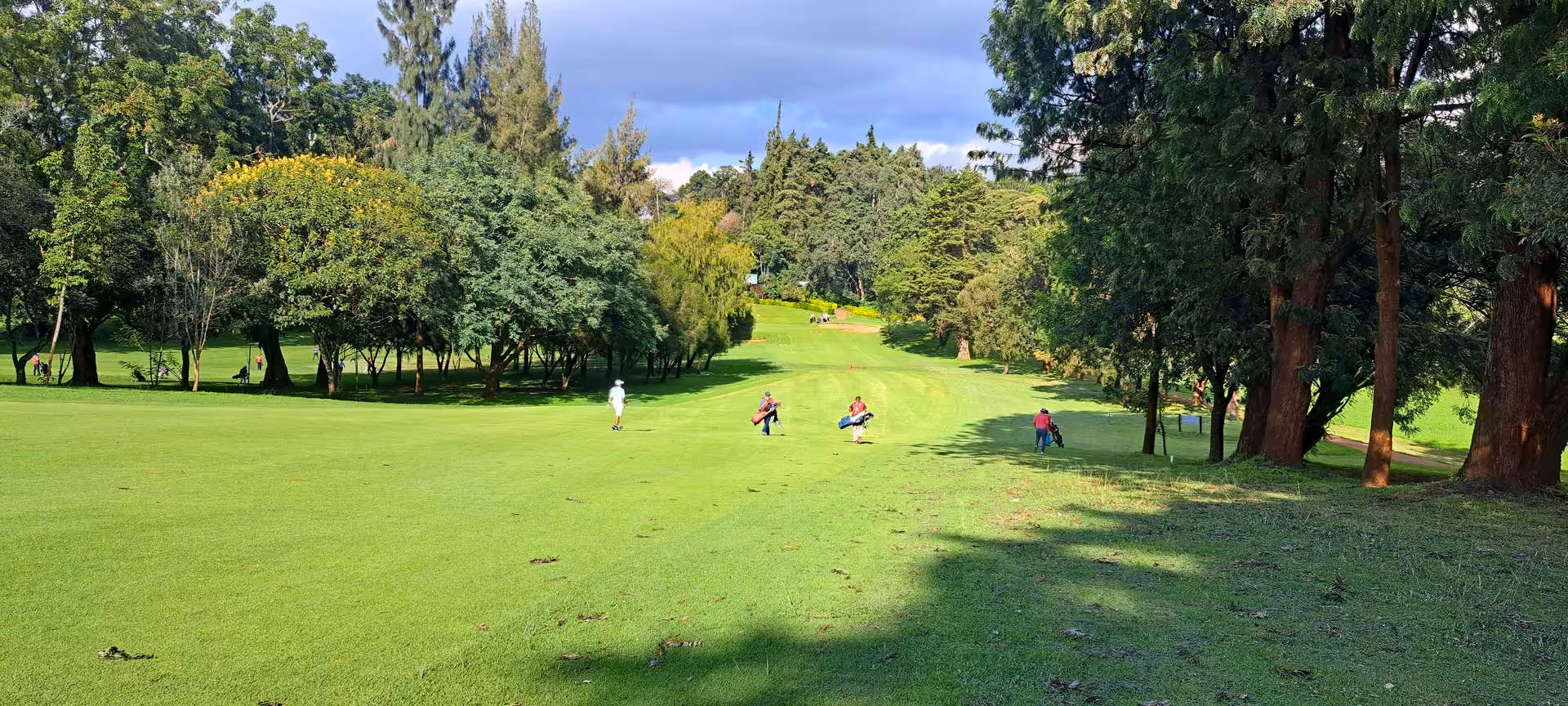 Lush golf course in Nairobi surrounded by trees, ideal for a serene golfing experience on the Kenya adventure tour.