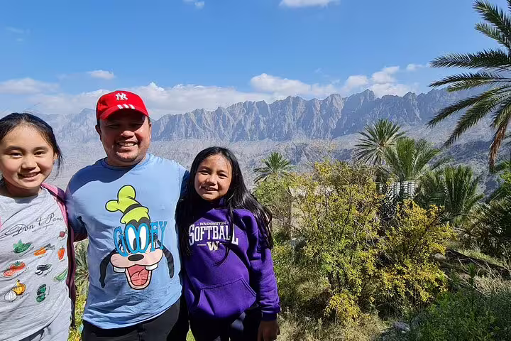 Visitors enjoying stunning mountain vistas and greenery at Wakan Village on the Nakhal Hotspring full-day tour.