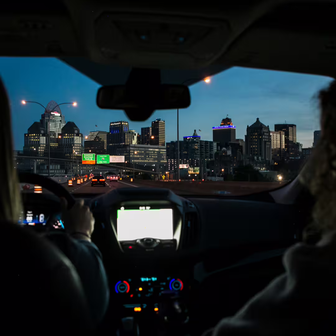 Couple enjoying night-time car transfer with city skyline views on route between Naples and the Amalfi Coast