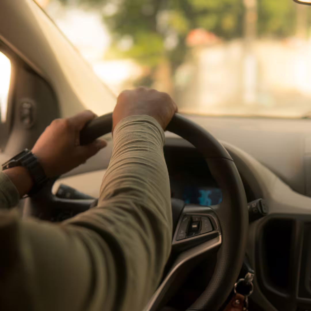 Close-up of driver’s hands on steering wheel providing safe, comfortable Naples to Amalfi Coast private transfer service