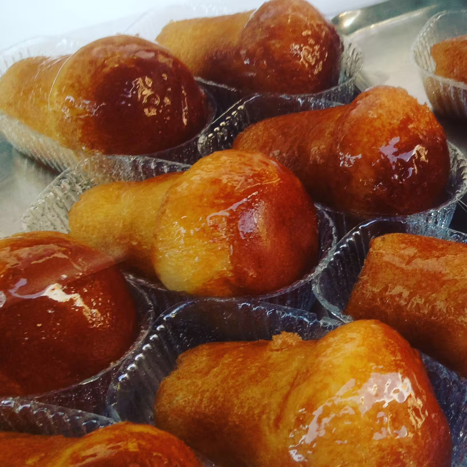 Tray of syrup-glazed baba pastries, iconic Neapolitan dessert stop on a Naples street food tour tasting