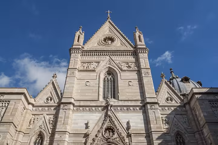 Detailed facade of Naples Cathedral under a clear blue sky, showcasing the city's rich architectural heritage.