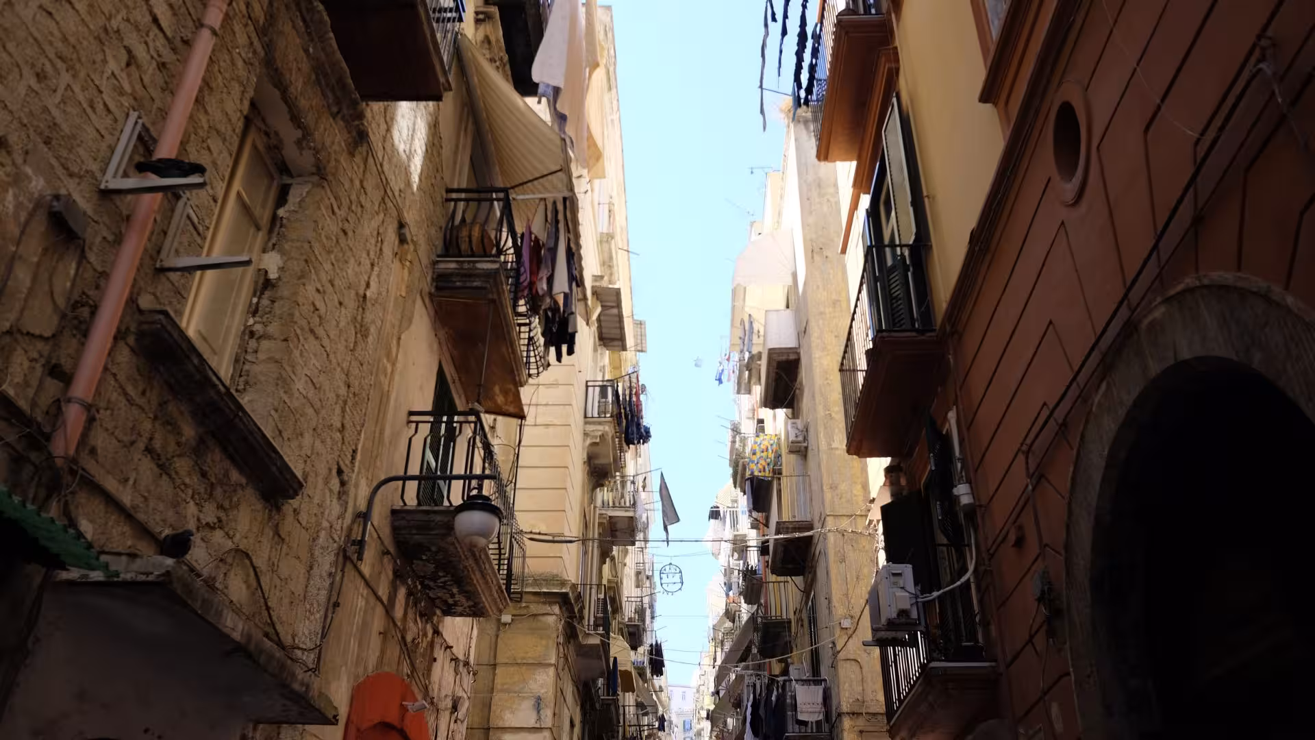 Narrow alleyway in Naples showcasing traditional Italian architecture, perfect for exploring folklore on a guided tour.