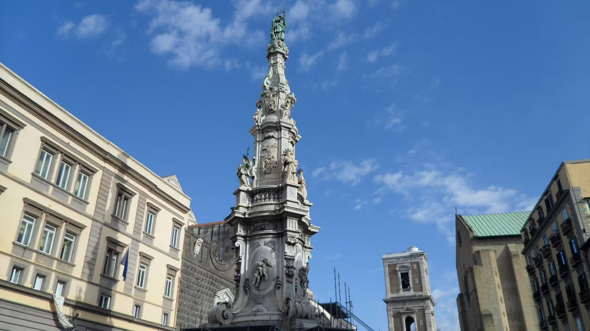 Monument in Piazza del Gesu Nuovo on Naples city walking tour, historic center under blue sky