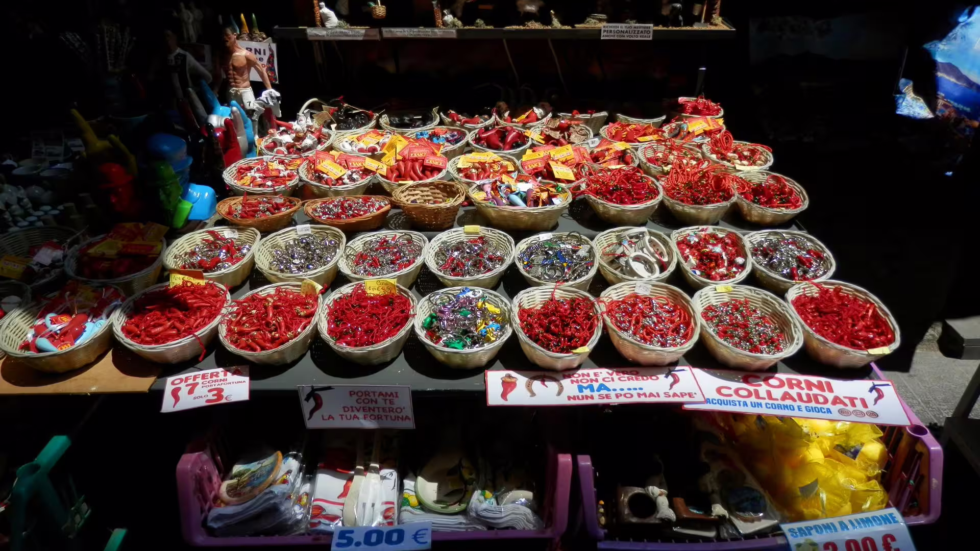 Cesti colmi di corni portafortuna rossi e souvenir tradizionali al Mercato della Pignasecca durante tour guidato di Napoli