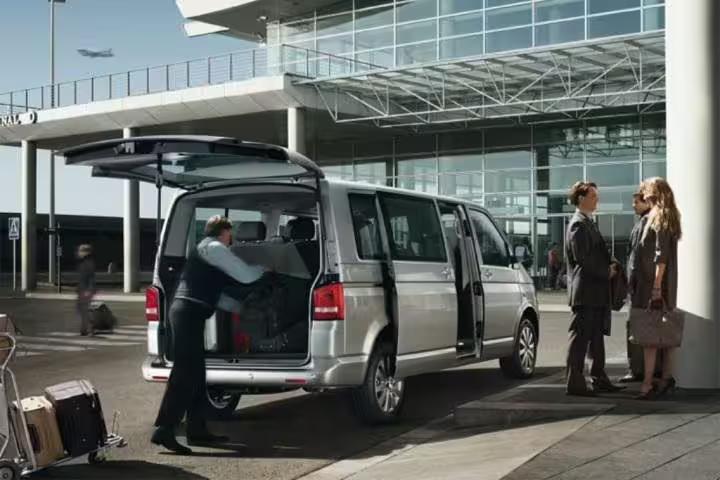 Private minivan driver loading luggage at Naples airport for executive transfer service to Ravello on the Amalfi Coast